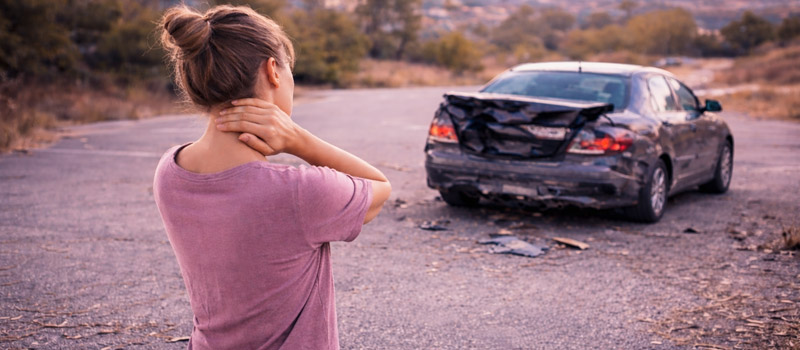 Woman holding her neck after a car accident, highlighting the need for chiropractic care in Longmont, Colorado
